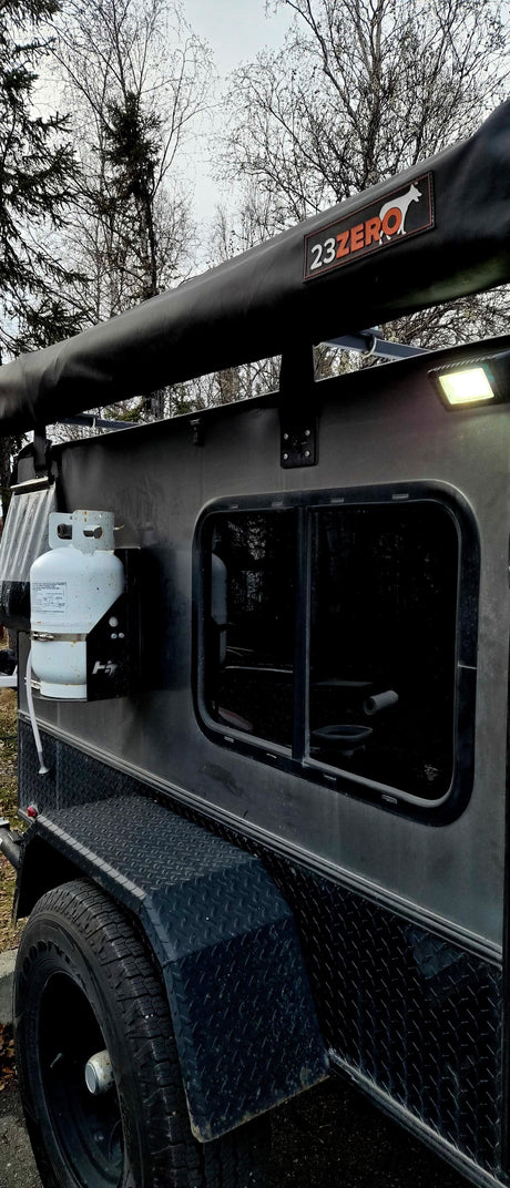 This rugged off-road utility trailer, perfect for RV rental, features a 23ZERO awning, propane tank, and side window.