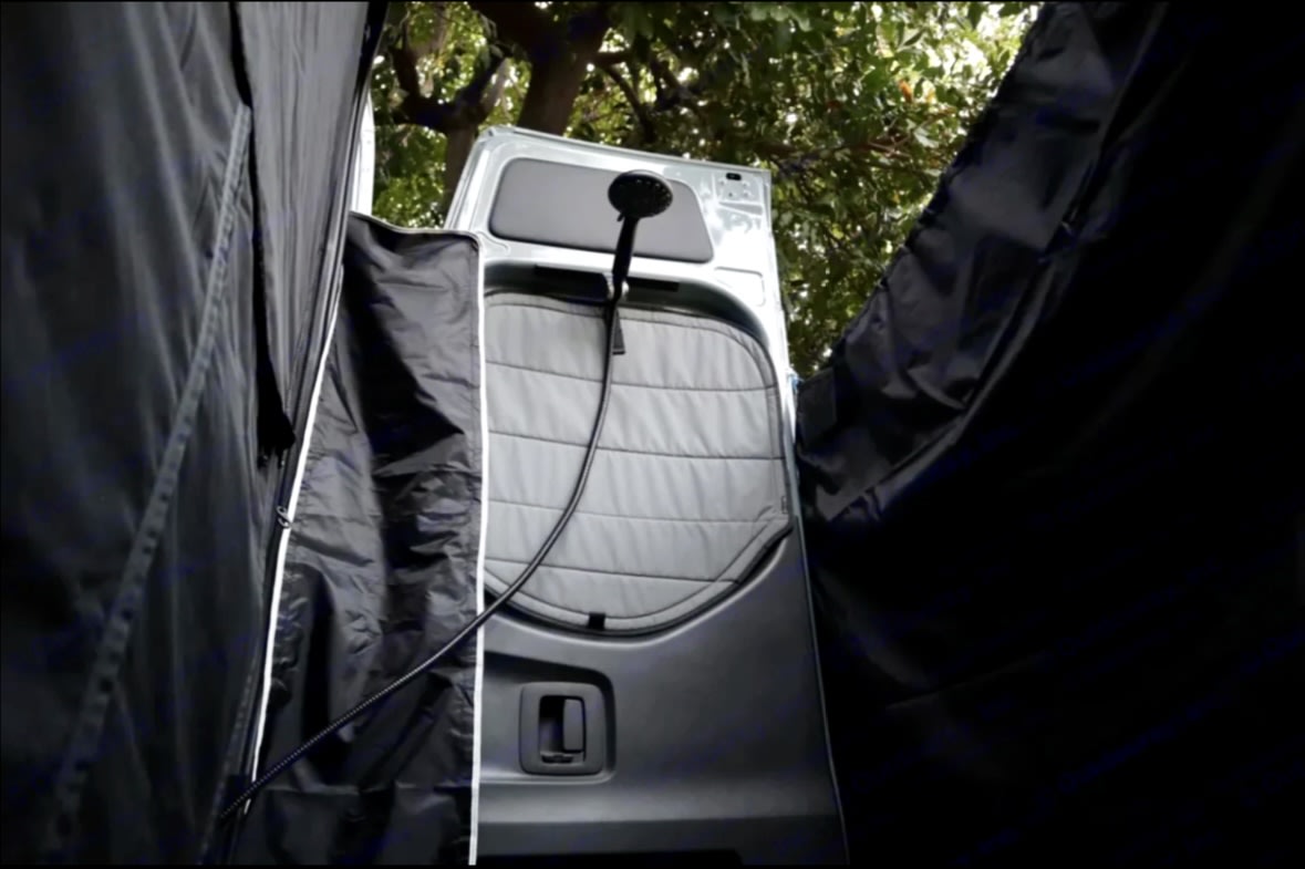 RV rental: Portable outdoor shower at vehicle rear, with black privacy enclosure. Ideal for camping.