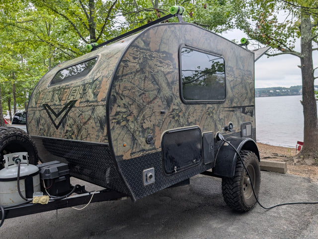 This rugged camouflage Sunray teardrop RV rental, perfect for lake camping, is powered up for adventure.