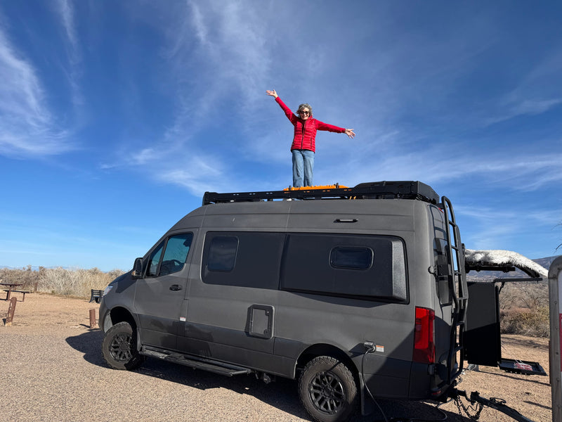  featuring a bed with a grey comforter and padded rear door panels.|RV rental: Camper van's front cabin features a Luno mattress sleeping setup — photo 19