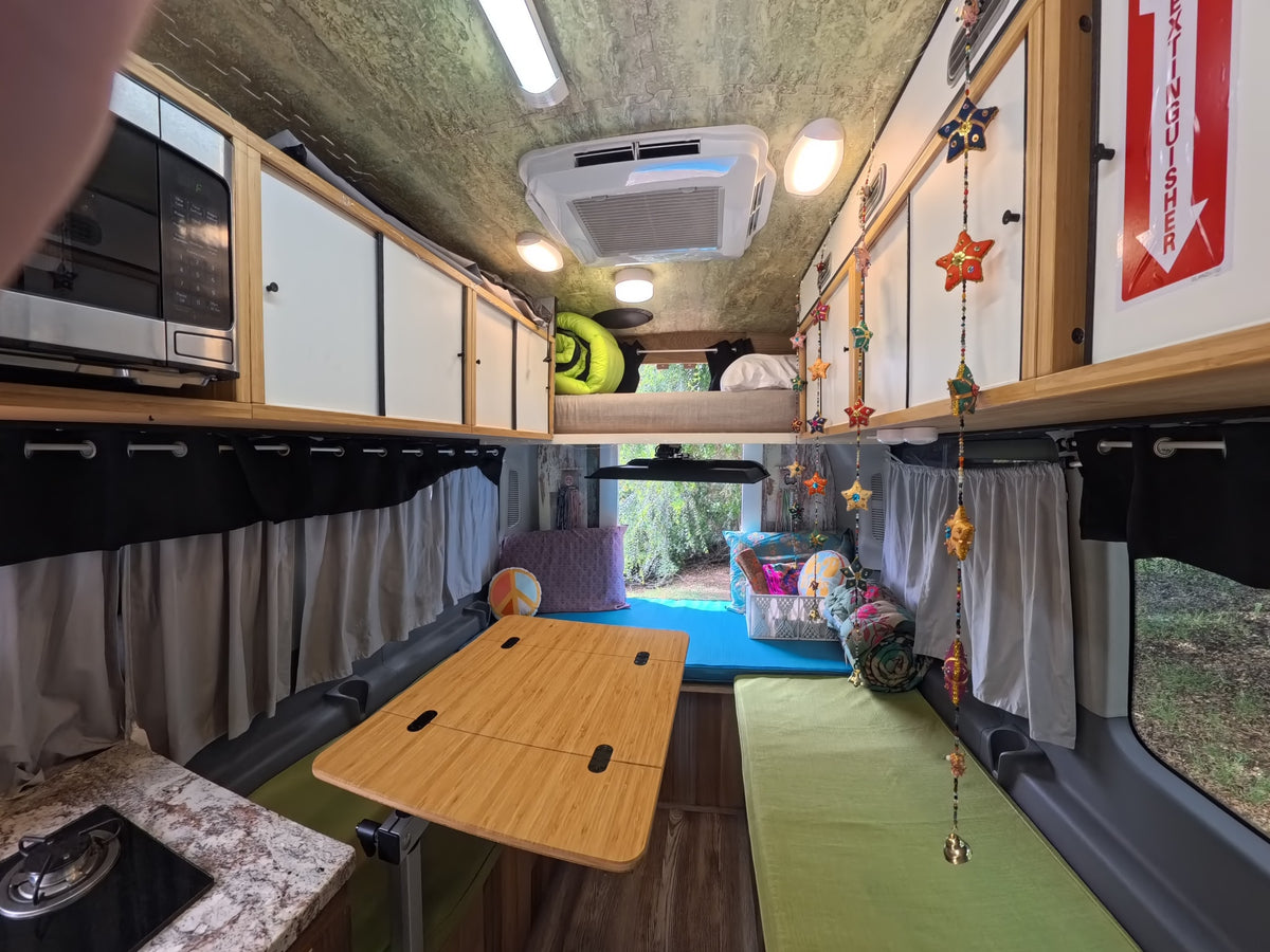  parked outdoors.|CLIFF RV rental: a black Ford Transit camper van with custom interior shown through its open side door — photo 9