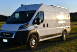 White Ram Promaster van, converted into an RV rental, shines in golden light, ready for camping & exploration.