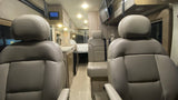 Step into this RV rental's inviting interior, revealing comfortable seats, a functional kitchen, and a rear sleeping area.