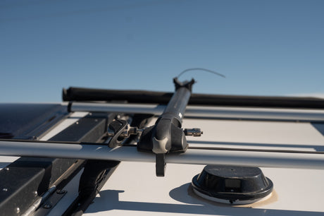 RV rental roof showing crossbars, a gear carrier, and a domed antenna, ready for your next adventure.