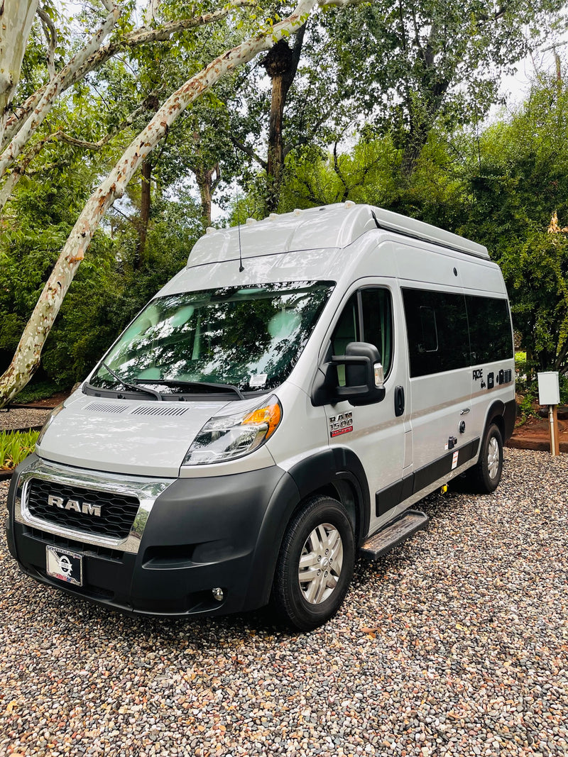  ready for adventure.|RV rental ready for adventure: white camper van with open door showing interior amenities. Outdoor table — photo 2