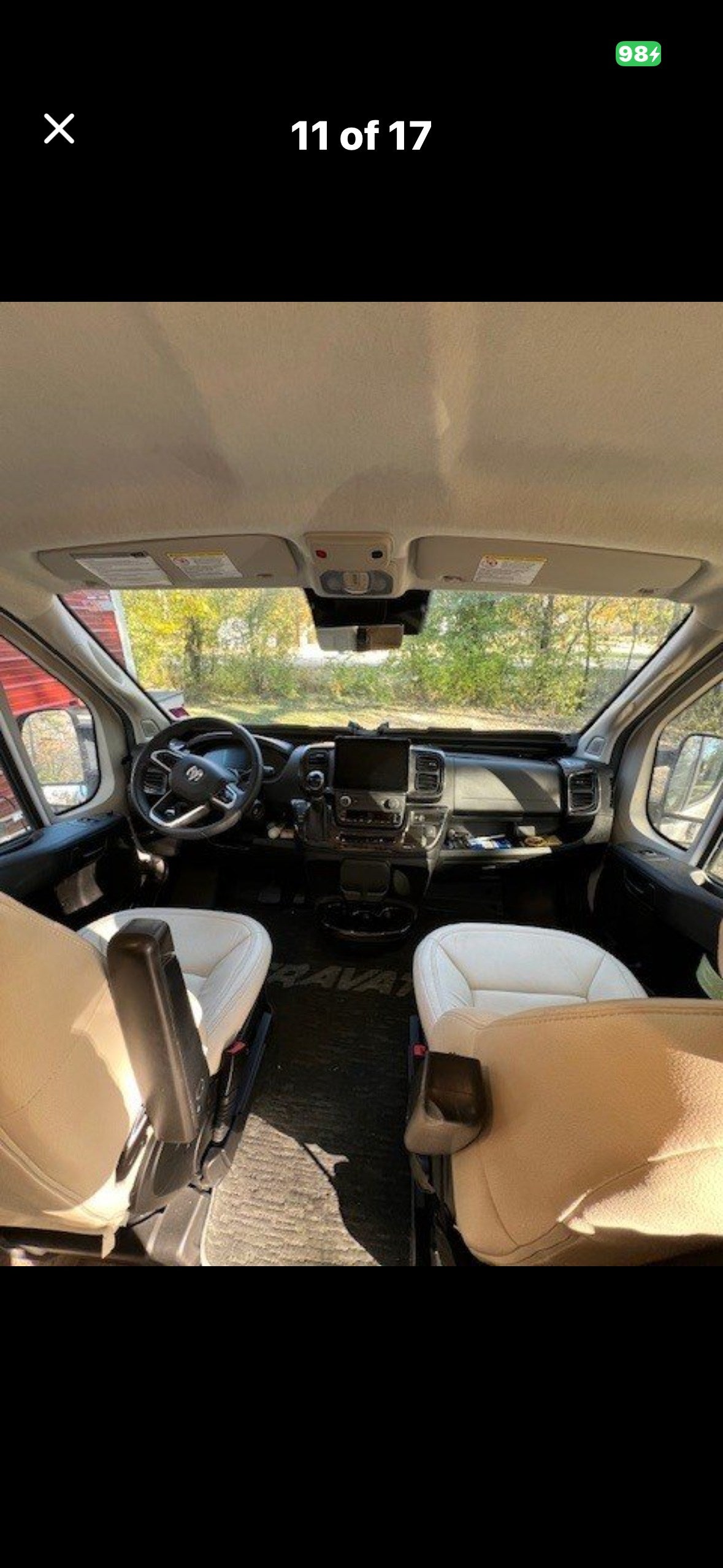 Bright RV rental cockpit with two swivel seats, detailed dashboard, and steering wheel, providing a clear view ahead.