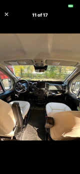 Bright RV rental cockpit with two swivel seats, detailed dashboard, and steering wheel, providing a clear view ahead.
