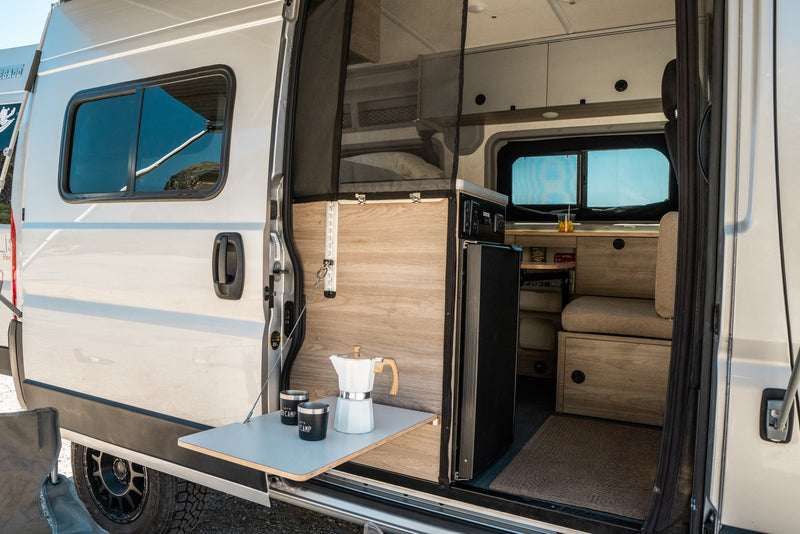 Inside this RV rental, discover a cleverly designed interior: outdoor coffee table, kitchen, fridge & convertible seating. — photo 9