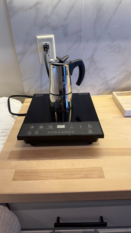 Compact kitchen setup for an RV rental: A Bialetti moka pot on an ISILER induction cooktop makes fresh coffee.