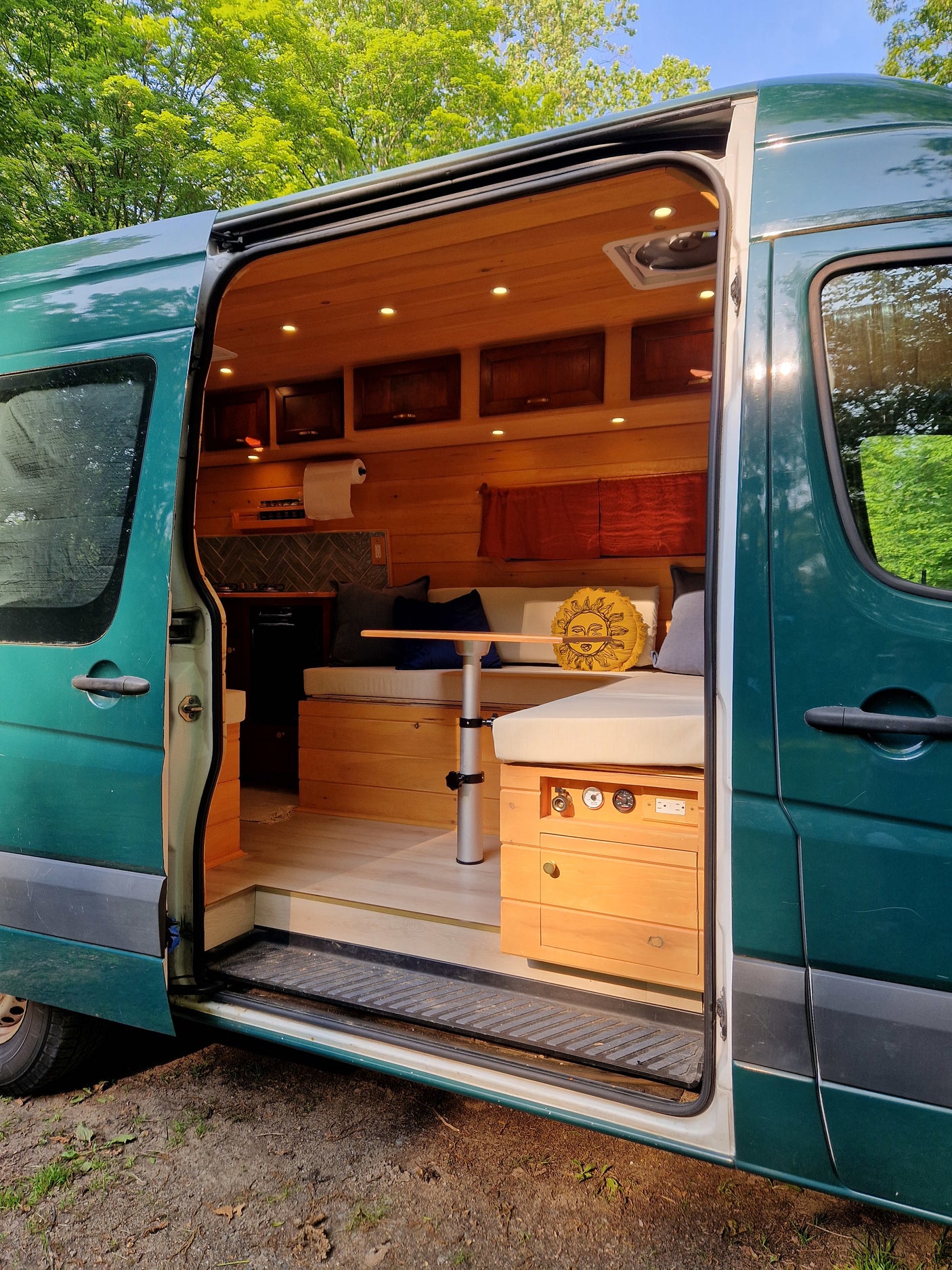 Interior of a teal custom van conversion, revealing a cozy wooden living space for rv rental.