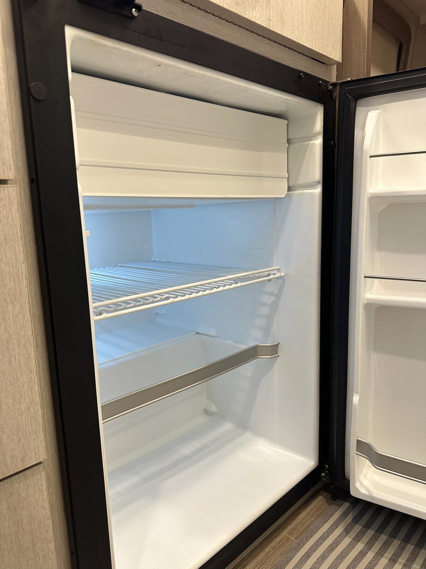  and kitchenette for comfortable journeys.|RV rental interior: A cozy dinette with beige seating and a table set with blue dishes — photo 8