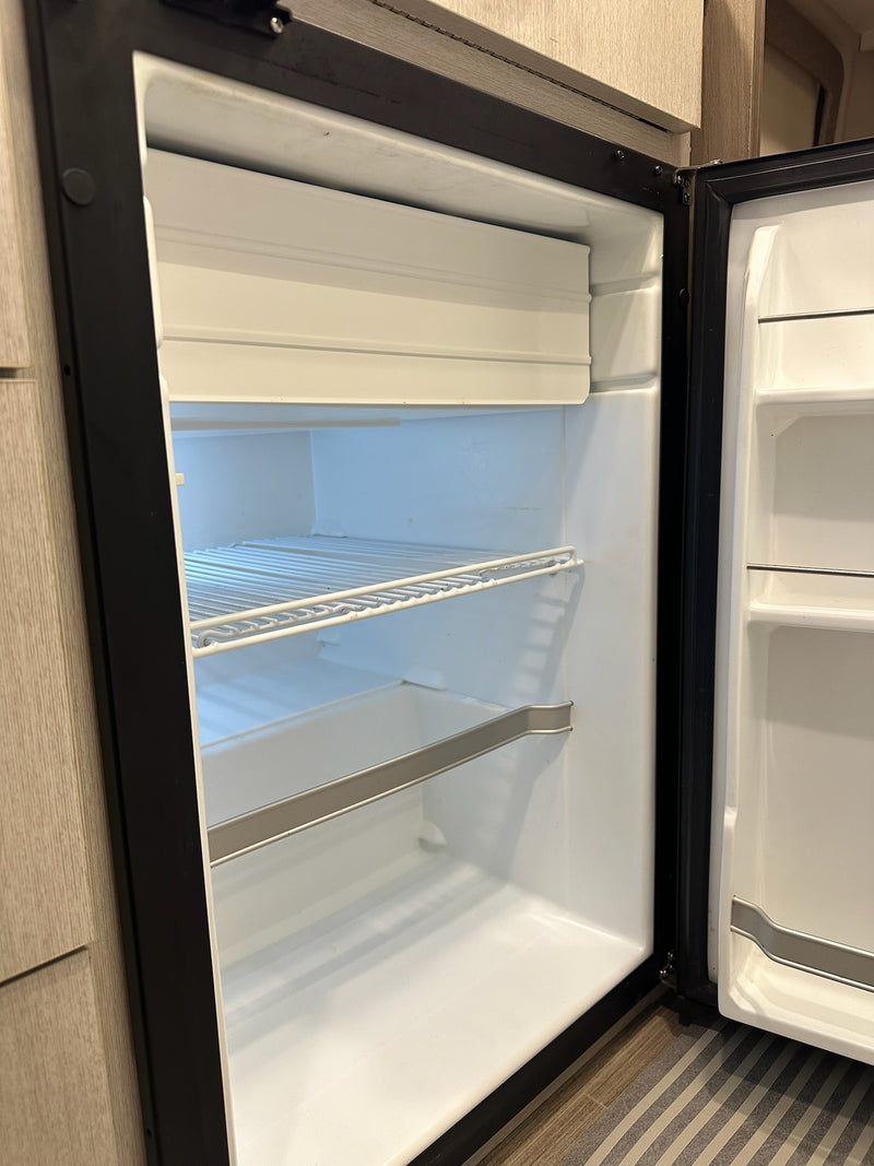  and kitchenette for comfortable journeys.|RV rental interior: A cozy dinette with beige seating and a table set with blue dishes — photo 8