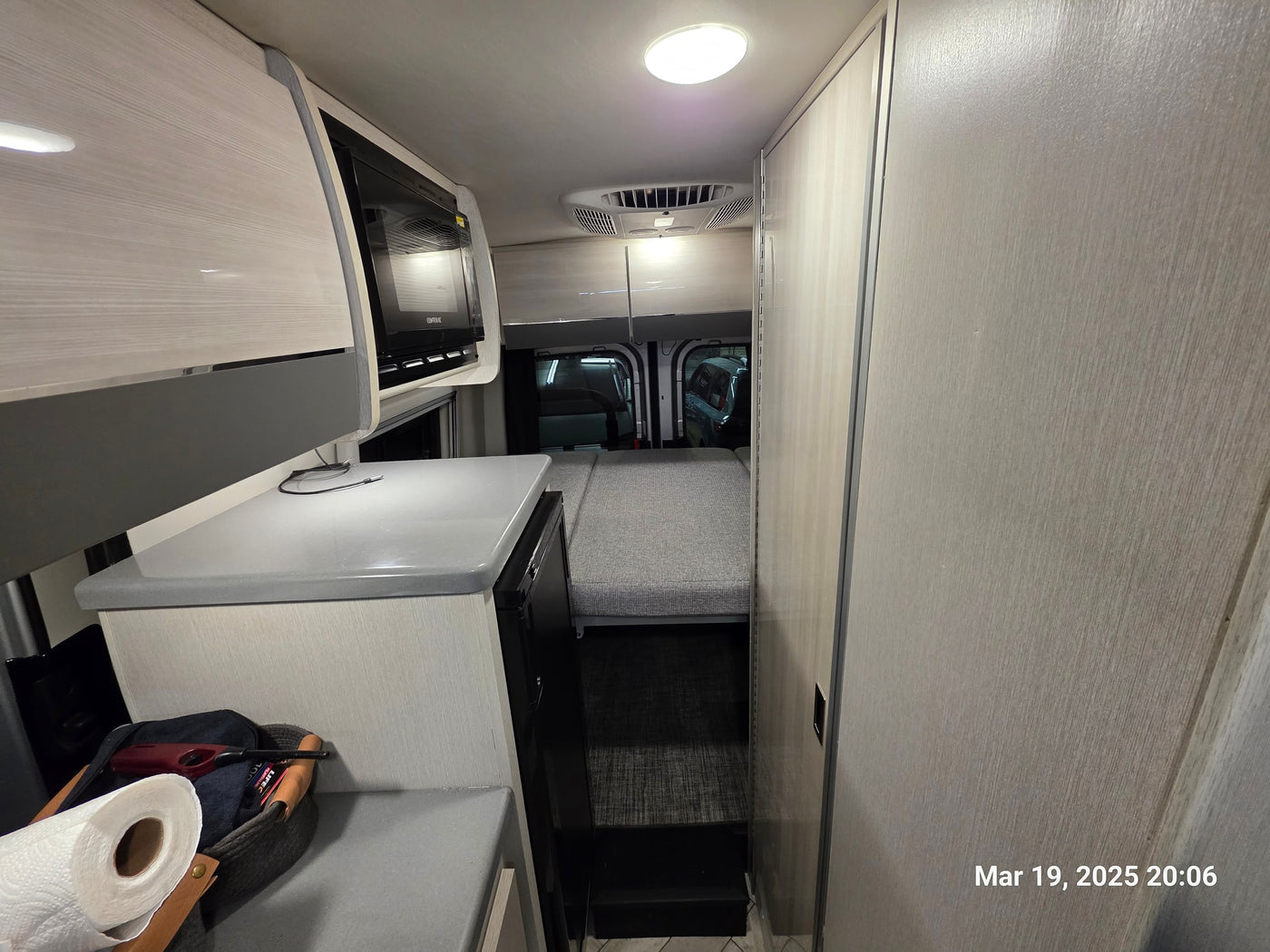  and bright ceiling lights.|Inside an RV rental: a modern dinette with TV and window — photo 11