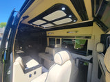 Step inside this premium RV rental: a luxurious van interior with cream leather seats, modern lighting, and ample space for executive travel.