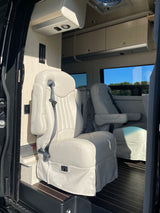 Inside this spacious RV rental: plush cream seats, wood floor, and controls. Enjoy comfortable road trips.