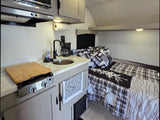  and fire pit under cloudy skies.|Cozy rv rental interior: compact kitchen with sink