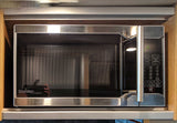 A stainless steel Danby microwave with a visible control panel, built into a wooden cabinet in an RV rental kitchen.