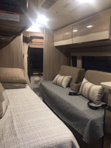 Cozy rv rental interior with two comfortable sleeping areas and modern cabinets.