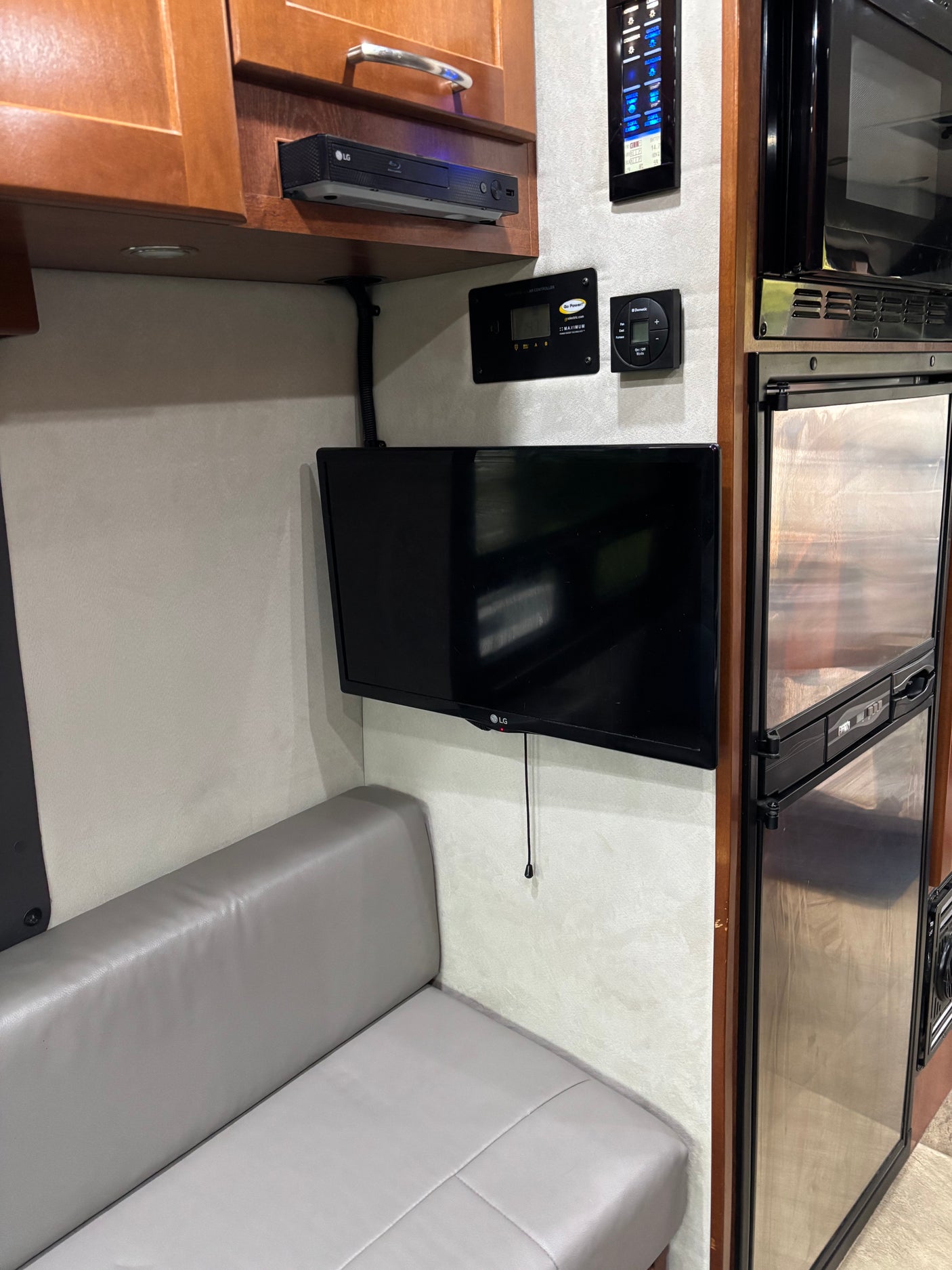 This RV rental boasts an entertainment setup with LG TV and Blu-ray, plus Go Power solar and Dometic climate controls above a comfy sofa.