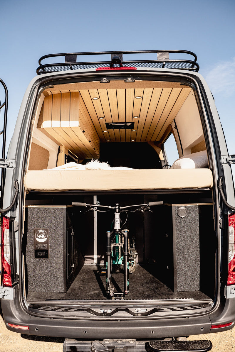  lit interior with kitchen amenities.|This RV rental features a modern van interior with swivel seats — photo 11