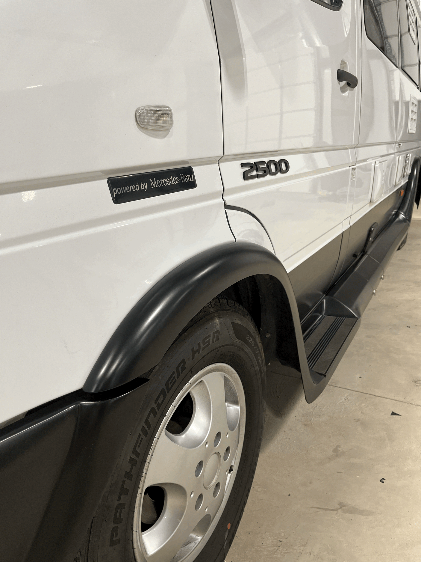 White Mercedes-Benz Sprinter 2500 van, ready for rv rental. Features black fender flares, running boards, and Pathfinder HSR tires.