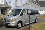 Silver Mercedes-Benz Sprinter RV conversion van, an ideal rv rental, parked on a paved driveway.