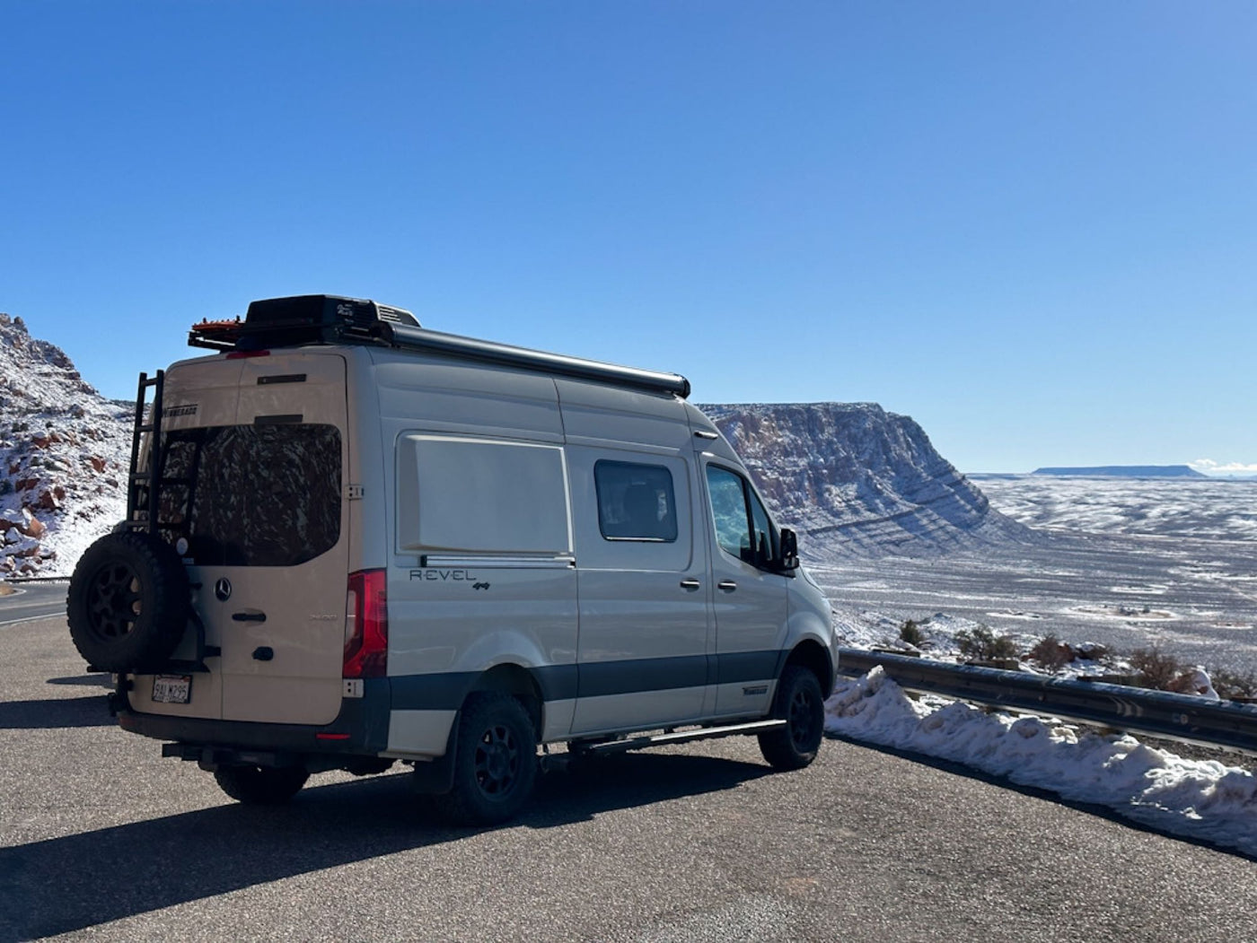  overlooking the ocean with waves & surfers. A wetsuit hangs on the fence near a picnic table.|Mobile office setup in an RV rental. Laptop with 'Cruise with Bruce' logo — photo 3