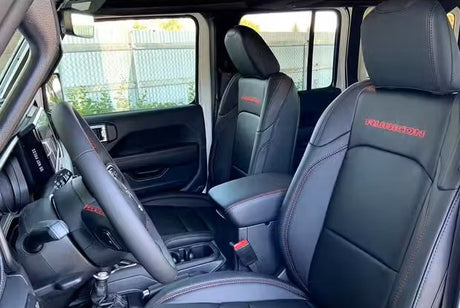 Clean Jeep Rubicon interior featuring black leather seats with red stitching, ready for your next RV rental adventure.