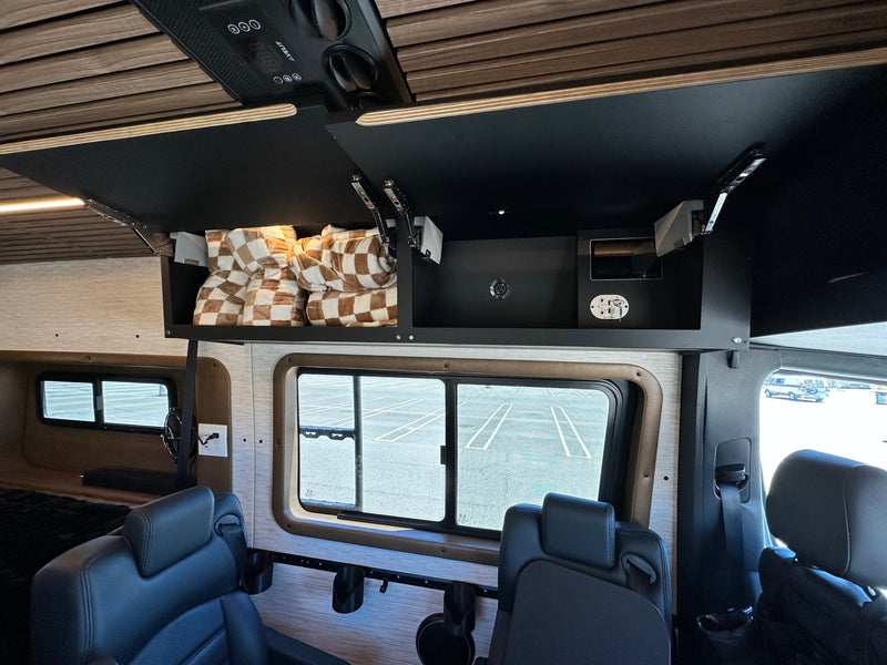  with palm trees and a sunny beach.|Spacious RV rental interior featuring black leather captain's chairs — photo 10