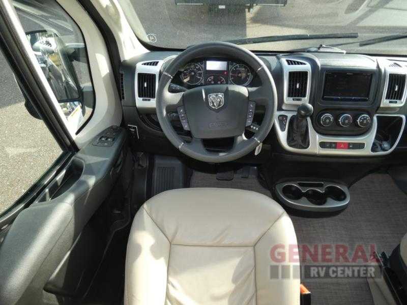 Inside an RV rental, showing the driver's cockpit, steering wheel with a Ram logo, and dashboard from the passenger side. — photo 9