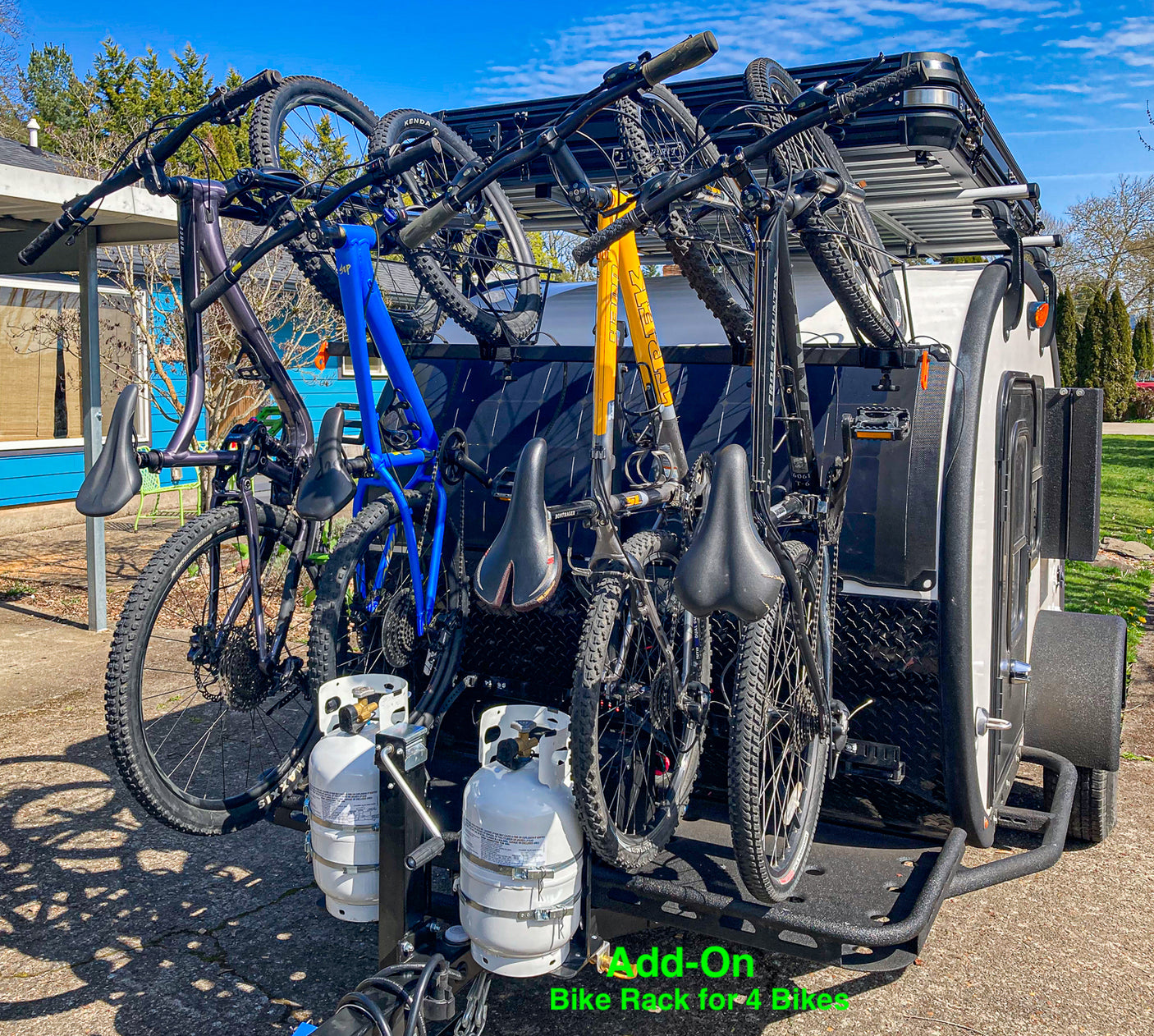 RV rental: Teardrop camper with custom bike rack holding 4 mountain bikes and two front-mounted propane tanks.