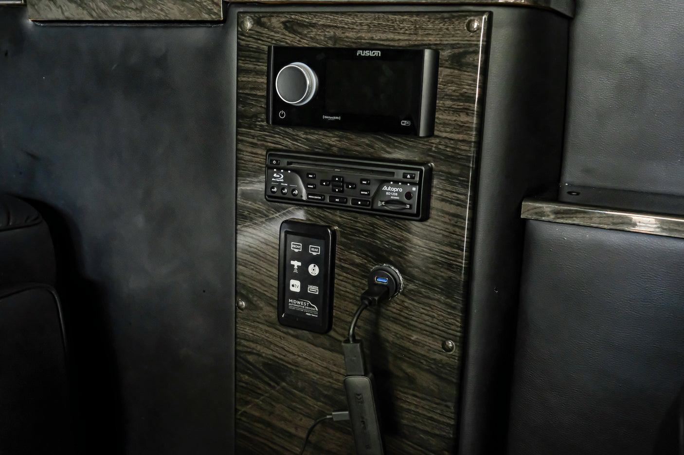 RV rental: Close-up of a luxurious interior control panel featuring Fusion stereo, Blu-ray player, and custom media controls.
