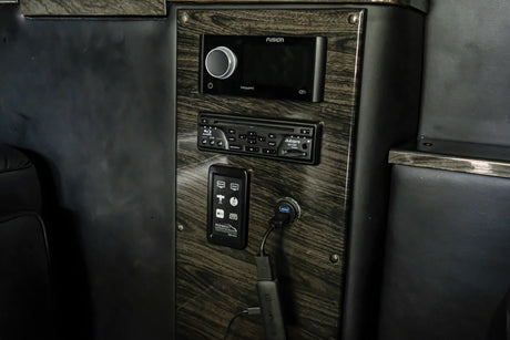 RV rental: Close-up of a luxurious interior control panel featuring Fusion stereo, Blu-ray player, and custom media controls.
