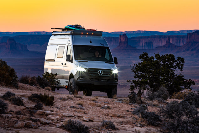 Mercedes Sprinter RV rental camper van on a desert trail at sunset, ready for off-road adventure.