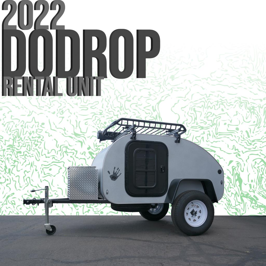 A grey 2022 DoDrop teardrop camper, an RV rental unit, shown with a roof rack and storage box, ready for adventure.
