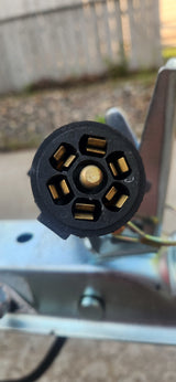 This close-up shows a 7-pin trailer electrical connector, essential for RV rental towing, providing lights and power.