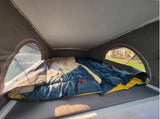 RV rental: Pop-top camper's sleeping area with two beds, soft bedding, and arched window views.