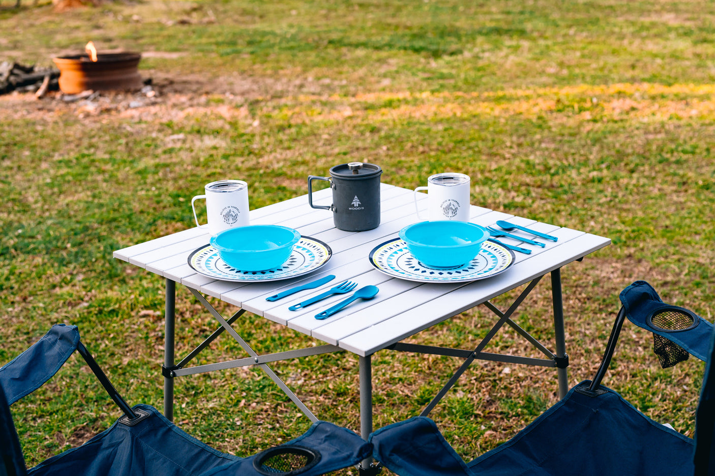 RV rental trip? Enjoy outdoor dining with a portable table set for two, cozy chairs, and a fire pit.