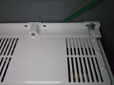 RV rental: Close-up of a white perforated vent panel, revealing interior wiring and a green cable connection.