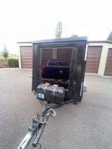 Black cargo trailer with truck and battery box at storage units. Perfect for hauling extra gear for your rv rental trip.