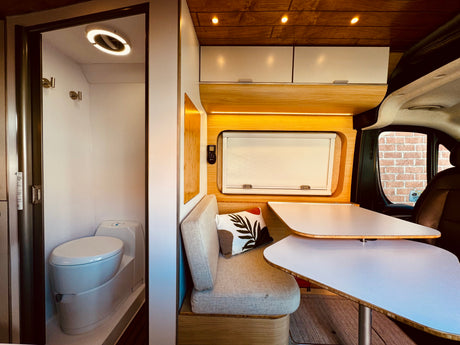 Modern RV rental interior: compact bathroom, cozy bench, and unique dining tables for comfortable travel.
