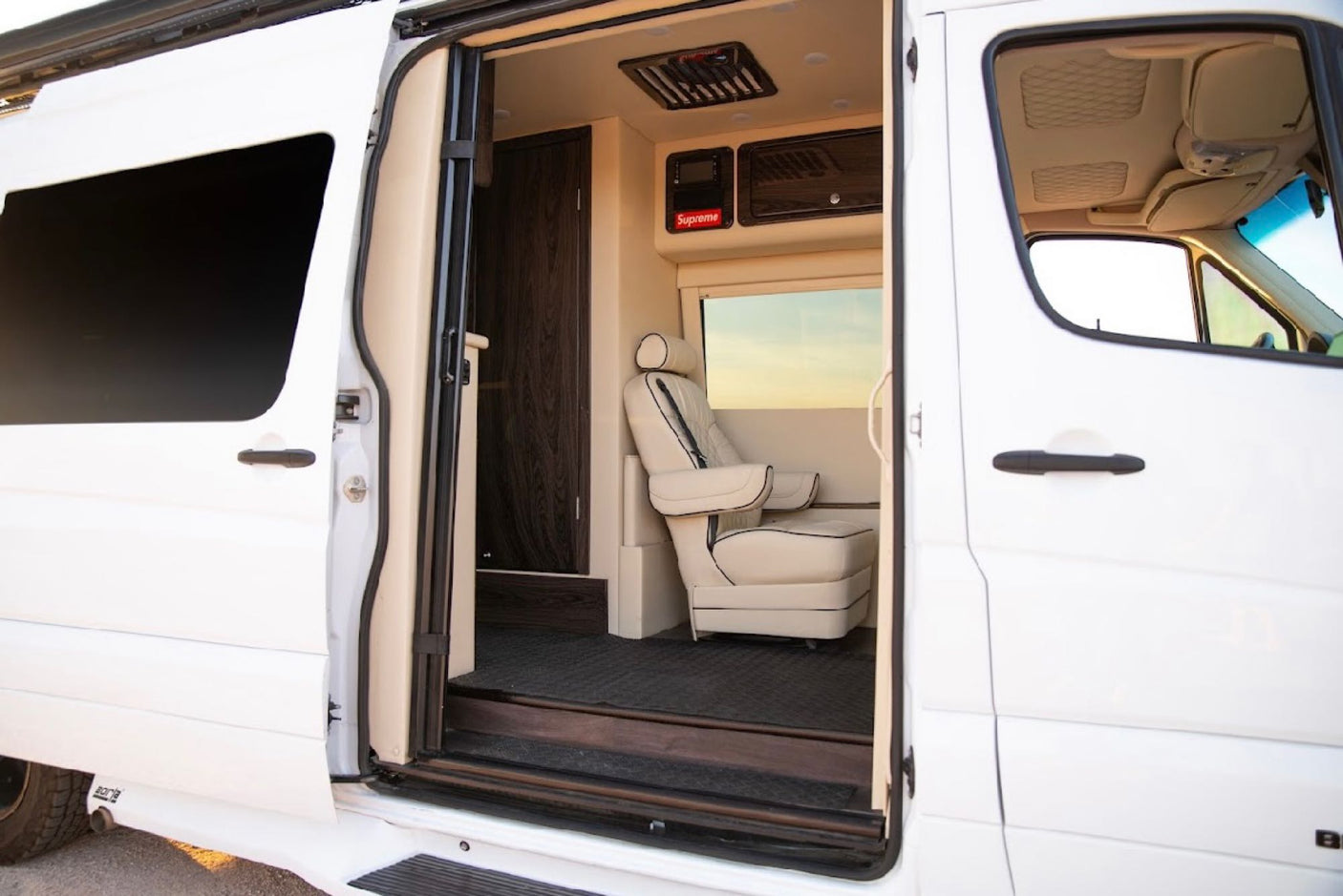 Explore this luxury RV rental interior: a custom van with plush seating and premium amenities.