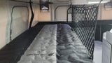 Explore an RV rental's sleeping area: a compact bunk bed with a two-tone gray mattress and safety net for secure, comfortable travel.