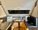 Experience comfort in this RV rental's clever interior. A laptop-ready dining area and scenic window views define this compact space.