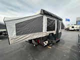 Experience camping with this pop-up camper! An excellent RV rental, it features fabric walls, windows, and an exterior grill setup.