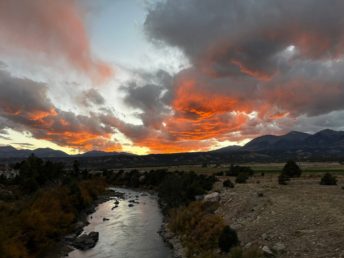 Vibrant orange & grey clouds illuminate a scenic river & mountains at sunset. Perfect for an RV rental adventure! — photo 6