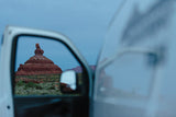 Stunning desert vista from an RV rental. A towering red rock formation framed by the open door of a white RV.