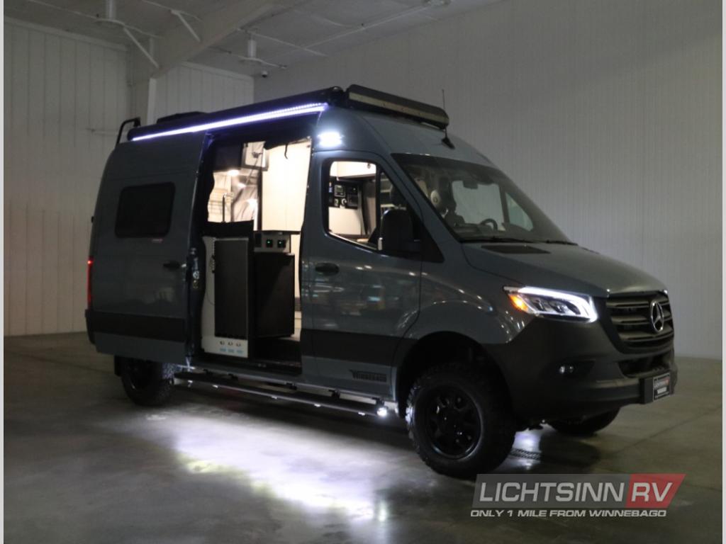 This dark gray Mercedes Sprinter RV rental camper van shows its open side door and illuminated interior, ready for adventure.