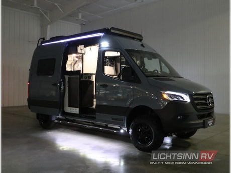 This dark gray Mercedes Sprinter RV rental camper van shows its open side door and illuminated interior, ready for adventure.