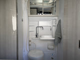 This RV rental wet bath features a space-saving toilet, fold-down sink, and shower, perfect for mobile travel comfort.